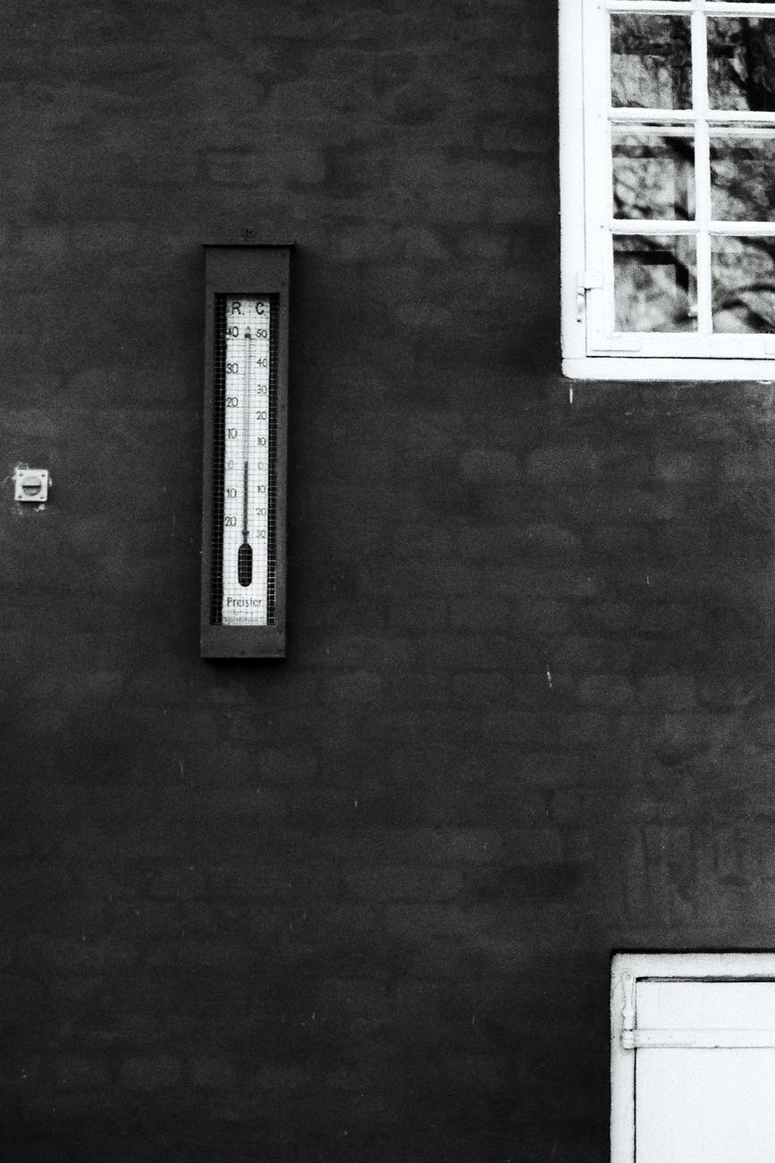 grayscale photography of thermometer on wall